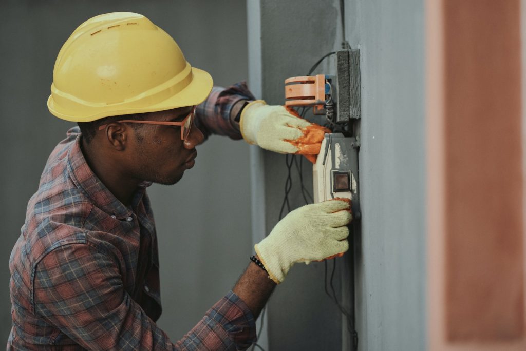 homme qui répare un conduit électricité