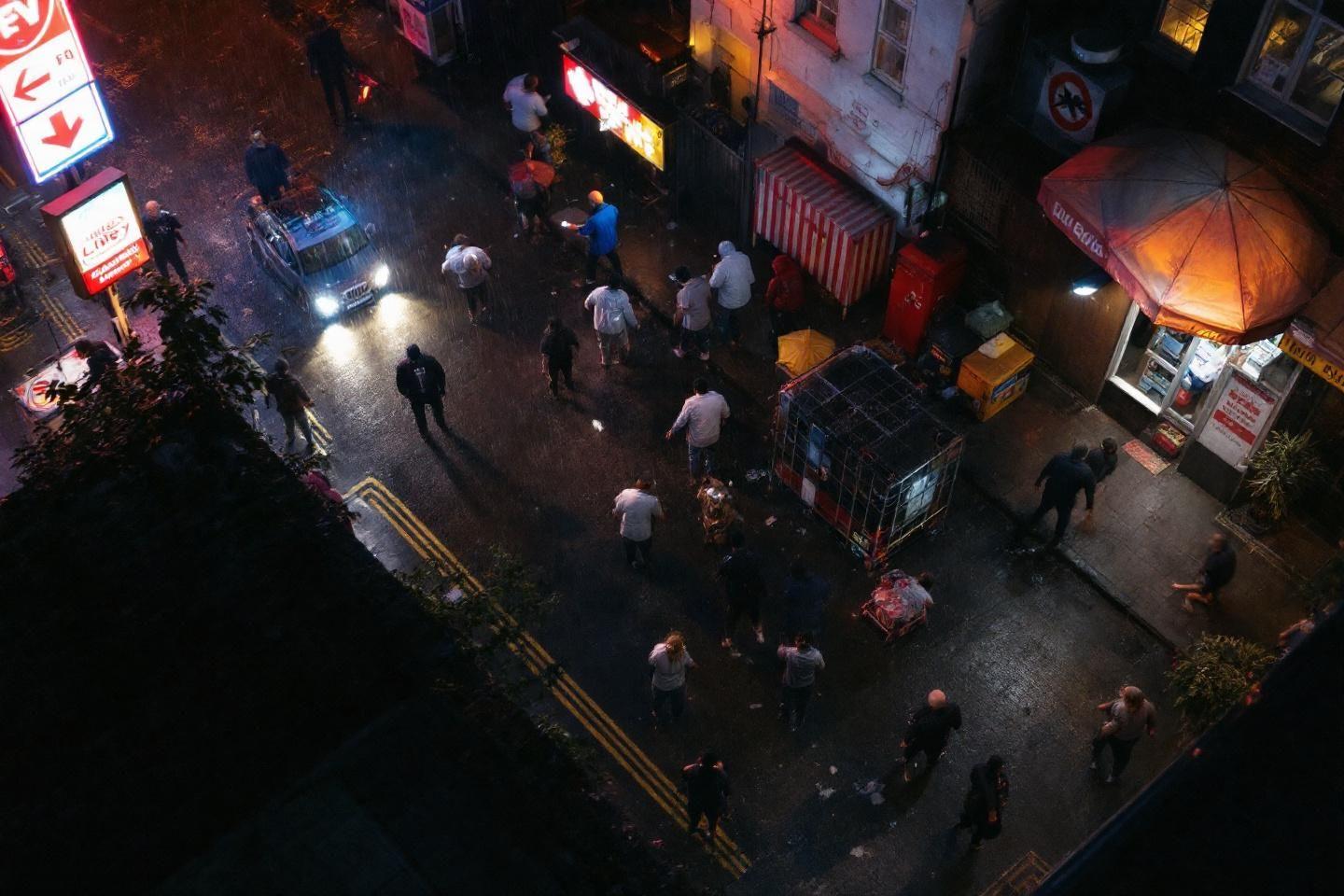 Vue aérienne nocturne d'une rue animée avec véhicules et piétons